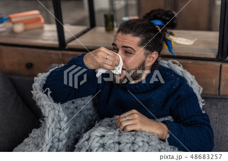 Unhappy young man suffering from running nose 48683257