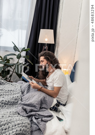 Joyful bearded man reading a book at home 48683294