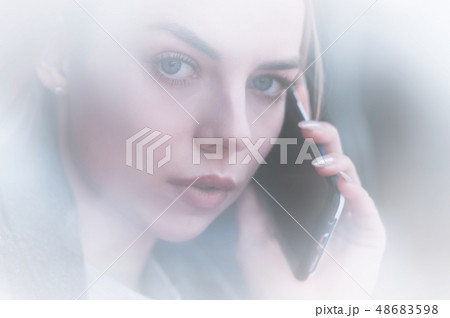 Closeup portrait attractive young girl talking on the phone look at camera. Non-contrast view Closeup portrait attractive young girl talking on the phone look at camera. Non-contrast view 48683598