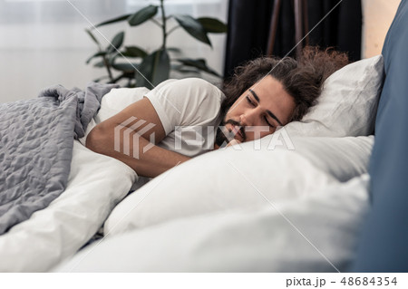 Handsome bearded man being in his bedroom Handsome bearded man being in his bedroom 48684354