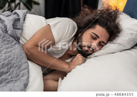 Pleasant handsome man lying on the pillow Pleasant handsome man lying on the pillow 48684355