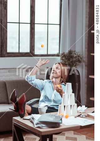 Woman going crazy at work playing with tennis ball 48684831