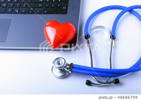 Workplace of doctor with stethoscope, red heart, laptop, rx prescription and notebook on white table 48686709