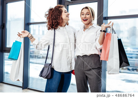 Happy curly daughter looking at her beautiful lovely mother Happy curly daughter looking at her beautiful lovely mother 48686764