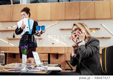 Businesswoman talking with partner and checking reports 48687427