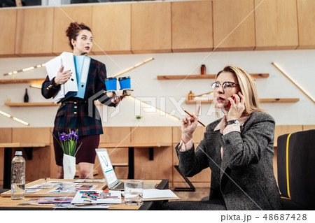 Businesswoman wearing glasses receiving phone call from partner 48687428