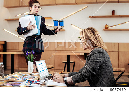 Busy personal secretary bringing takeaway coffee to her female boss Busy personal secretary bringing takeaway coffee to her female boss 48687430