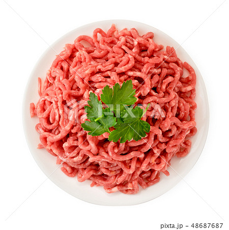Minced meat in a plate and parsley leaves on a Minced meat in a plate and parsley leaves on a 48687687