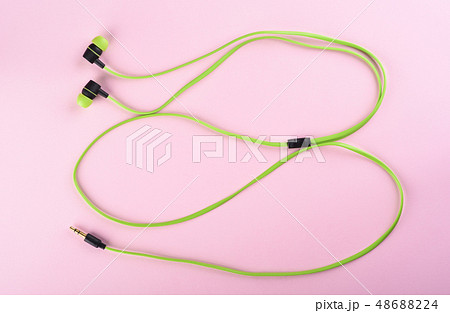 Green headphones or earphones isolated on a pink 48688224