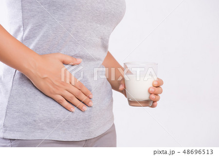 Woman holding glass of milk having stomach ache 48696513