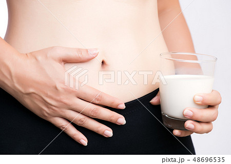 Woman holding glass of milk having stomach ache 48696535