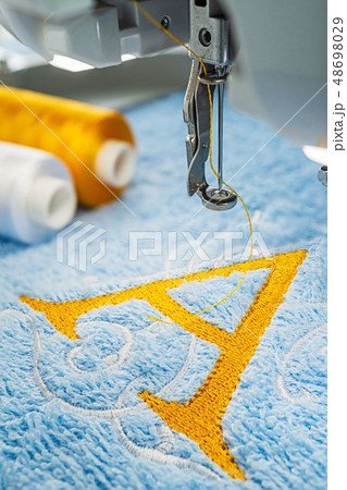 Embroidery machine and alphabet logo on towel Embroidery machine and alphabet logo on towel 48698029