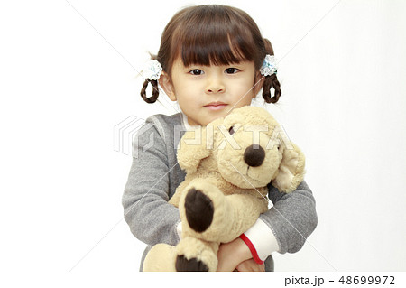 犬のぬいぐるみを抱える幼児 4歳児 白バック の写真素材
