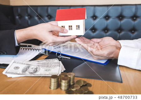 Estate agent sending house model to client after signing agreeme 48700733