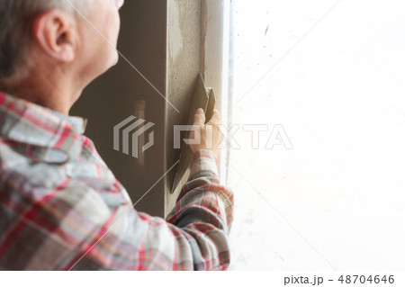 Plasterer working on a window opening Plasterer working on a window opening 48704646