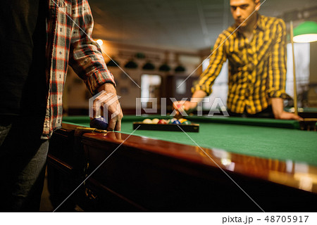 Two male billiard players places colorful balls Two male billiard players places colorful balls 48705917