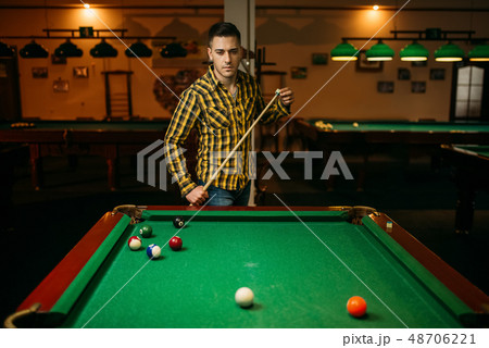Male billiard player with cue at the table Male billiard player with cue at the table 48706221