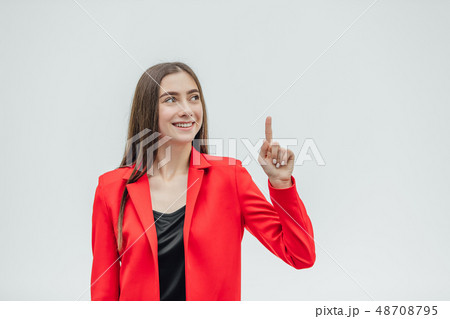 Portrait of a beautiful young brunette. Look into the camera. During this, the girl raised her hand Portrait of a beautiful young brunette. Look into the camera. During this, the girl raised her hand 48708795