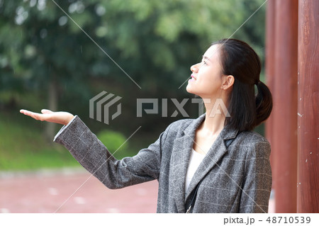 雨宿りしている若い女性 48710539