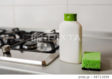 Cleaning product in plastic bottle at gas stove. Cleaning product in plastic bottle at gas stove. 48711699