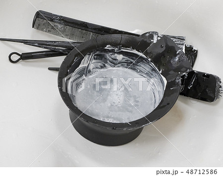 Dirty bowl for mixing hair dye in the sink. Dirty bowl for mixing hair dye in the sink. 48712586