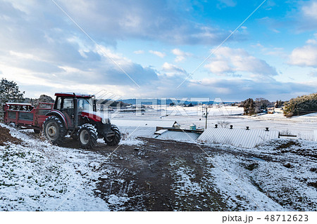 雪をかぶり出番を待つトラクターと堆肥散布機マニアスプレッダ 雪をかぶり出番を待つトラクターと堆肥散布機マニアスプレッダ 48712623