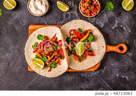 FAJITAS with colored pepper and onions, served FAJITAS with colored pepper and onions, served 48713062