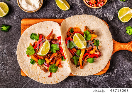 FAJITAS with colored pepper and onions, served 48713063