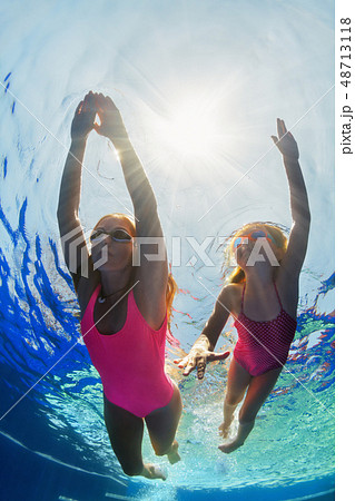 Child with mother dive in swimming pool Child with mother dive in swimming pool 48713118