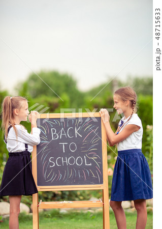 Happy little schoolgirls with a chalkboard outdoor 48715633