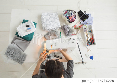Tailor, fashion and seamstress concept - young female fashion designer in her showroom, top view 48716270