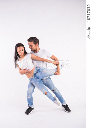 Young couple dancing social latin dance bachata, merengue, salsa. Two elegance pose on white Young couple dancing social latin dance bachata, merengue, salsa. Two elegance pose on white 48717039