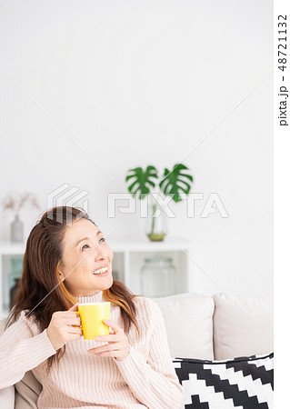 部屋でリラックスするシニア女性　飲み物 48721132