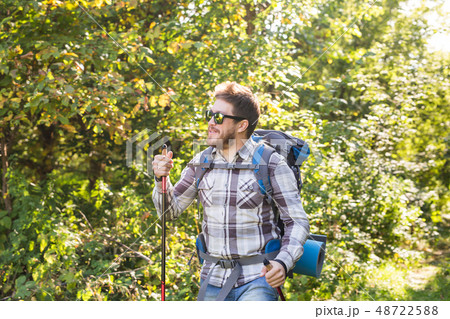 Hike, tourism and nature concept - Young traveler with backpack standing over forest background 48722588