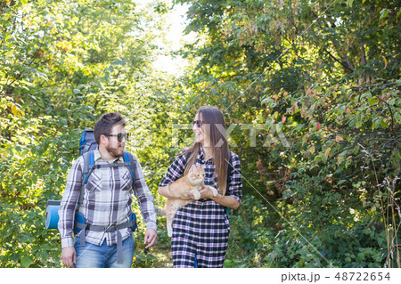 Travel, adventures, hike, tourism and nature concept - Tourist couple with cat walking in the woods 48722654