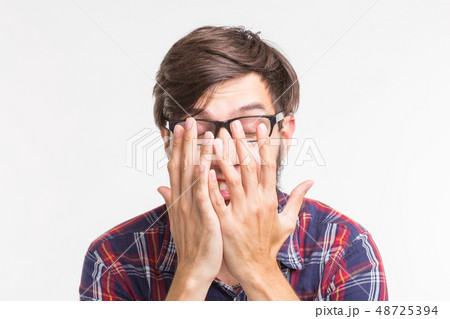 People, feelings and gesture concept - scared man hiding behind his hands from something unseen on People, feelings and gesture concept - scared man hiding behind his hands from something unseen on 48725394