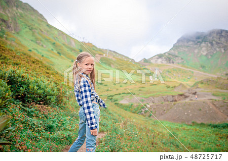 Beautiful happy little girl in mountains in the background of fog 48725717