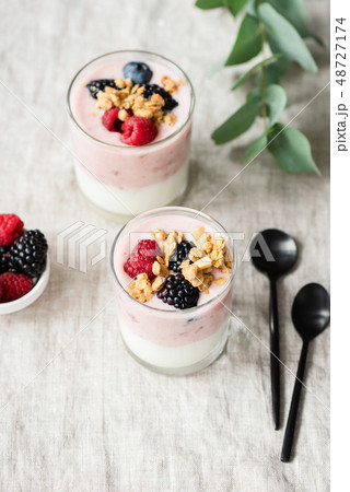 Yogurt with berries and granola in glass cup 48727174