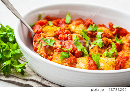 Baked vegan bean meatballs in tomato sauce. 48728292