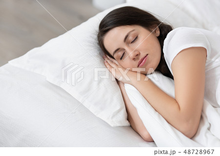 girl sleeping on white bed 48728967