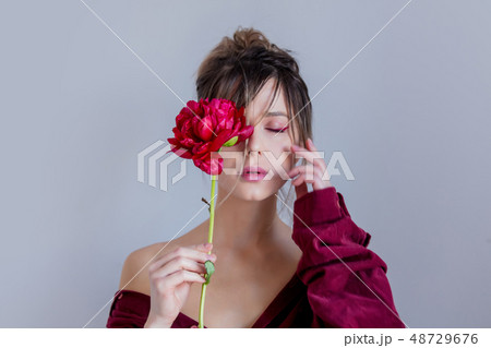 Female in red shirt holing red peony Female in red shirt holing red peony 48729676