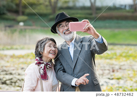 スマホで自撮りをする日本人シニア夫婦 国内旅行の写真素材