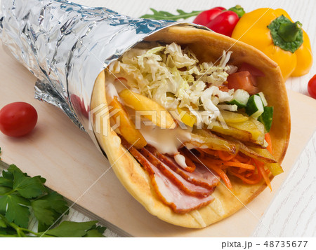 pita with bacon in foil on a light wooden background pita with bacon in foil on a light wooden background 48735677