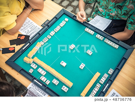 People Playing Mahjong Asian Tile-based Game. Table Gambling top view 48736776