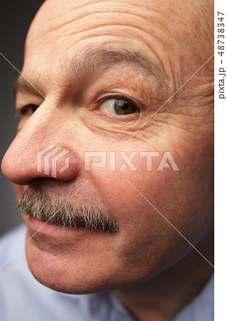 old man with a mustache looks curiously