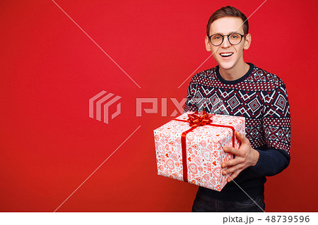 Happy guy in glasses with a gift box in hands 48739596