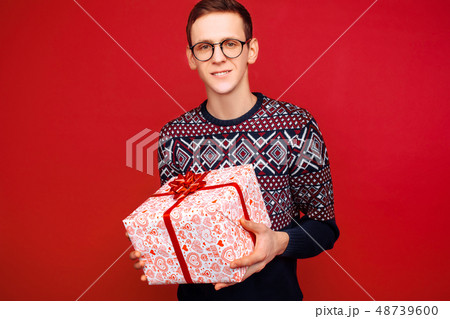 Happy guy in glasses with a gift box in hands 48739600