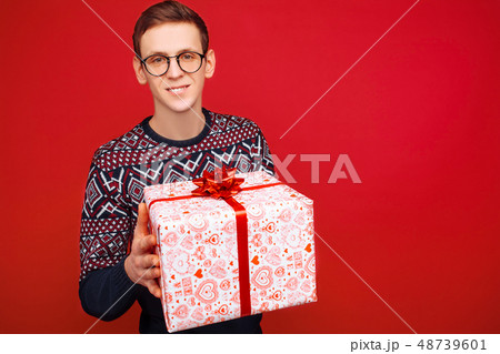 Happy guy in glasses with a gift box in hands 48739601
