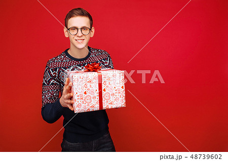 Happy guy in glasses with a gift box in hands 48739602