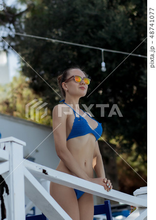 Sensual woman leaning on railing on resort 48741077